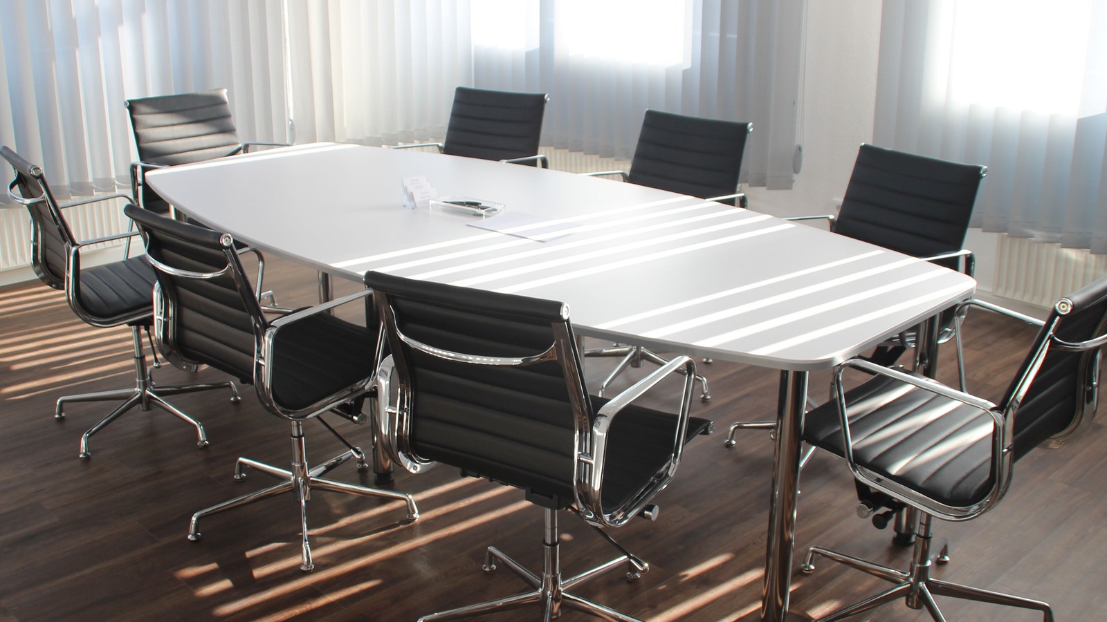 tomt bord med stolar i möteslokal