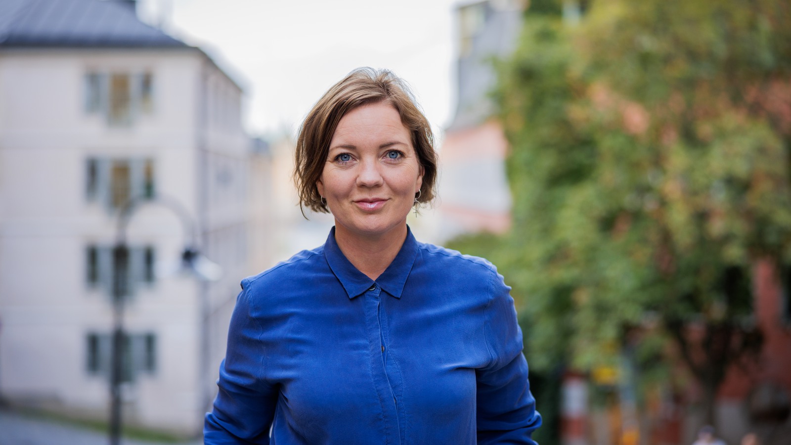 Porträttbild på Anna Lirén, gata i Stockholm i bakgrunden